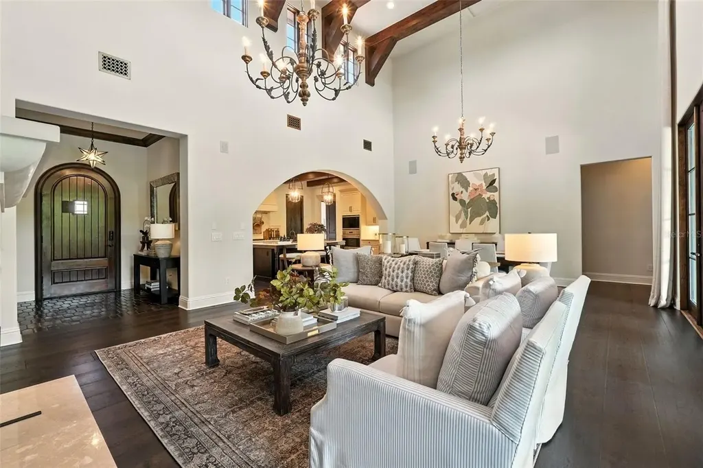 Elegant living room with vaulted ceilings and stone fireplace at 10075 Symphony Grove Dr, Orlando Home for sale
