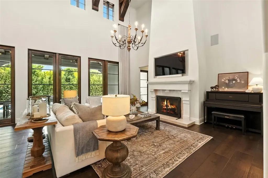 Elegant living room with vaulted ceilings and stone fireplace at 10075 Symphony Grove Dr, Orlando Home for sale