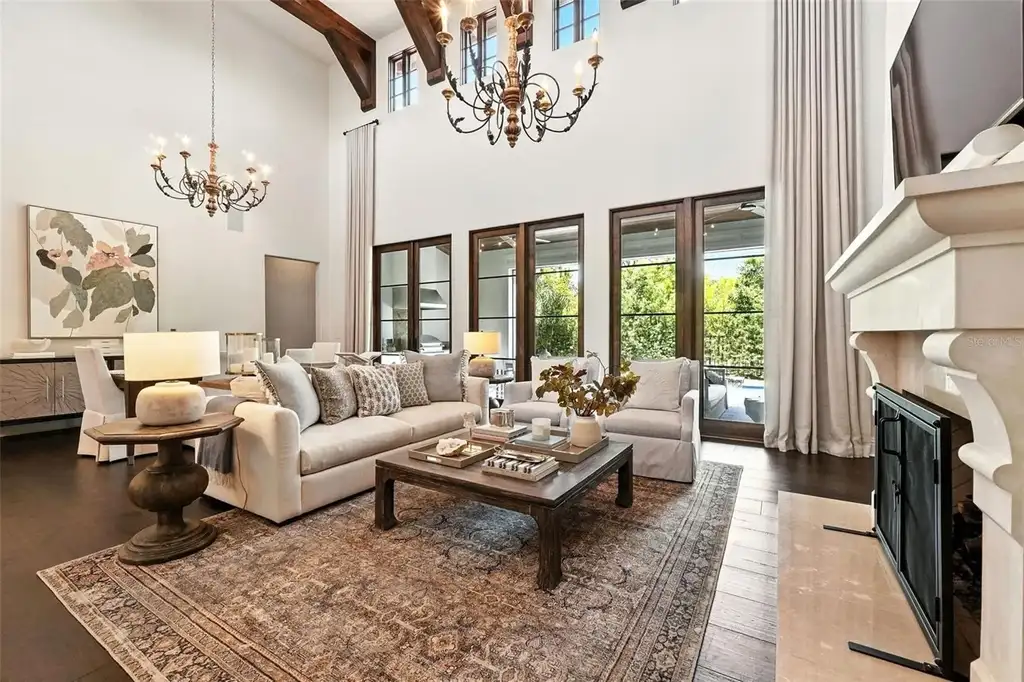 Elegant living room with vaulted ceilings and stone fireplace at 10075 Symphony Grove Dr, Orlando Home for sale