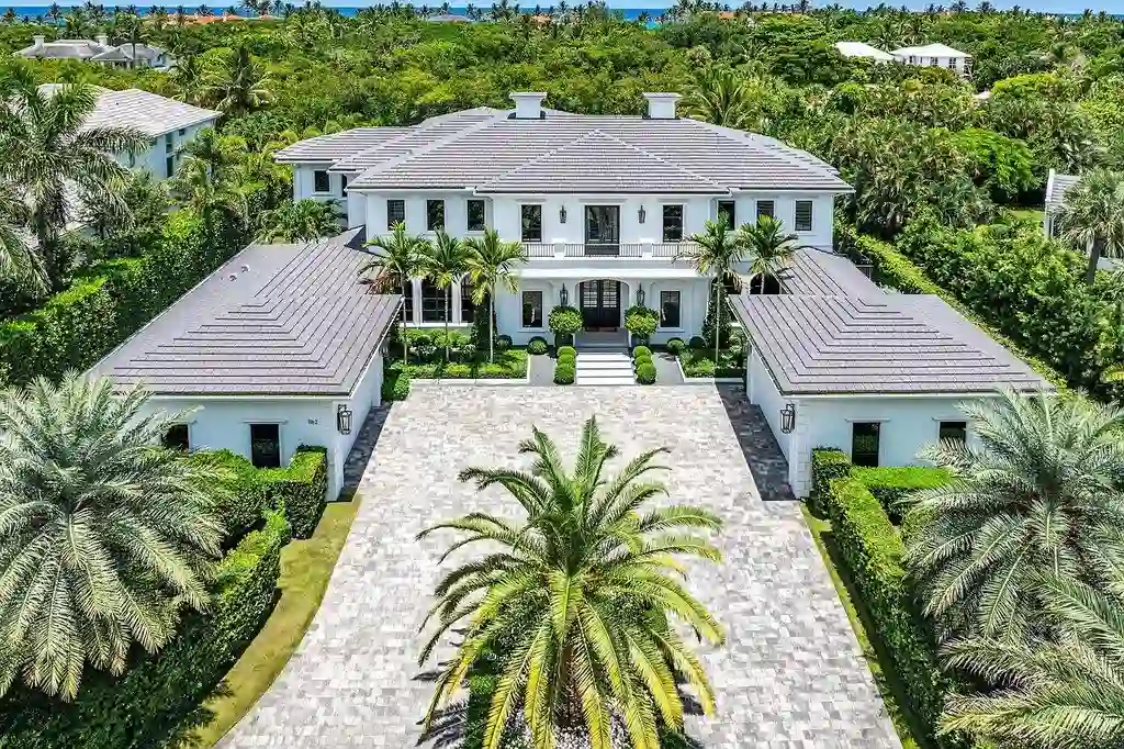 Luxury estate at 1162 Banyan Estates Drive with infinity pool, tropical landscape, and modern design in gated Seminole Landing, North Palm Beach, FL.