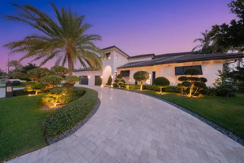 Front exterior of 2900 NE 23 Place Pompano Beach with lush landscaping and circular driveway
