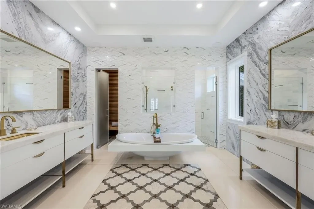 Infinity-edge saltwater pool and private dock at luxury home in Naples for sale, located on Venetian Bay with waterfront views.