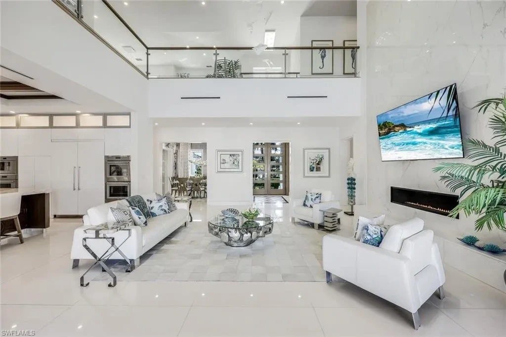 Infinity-edge saltwater pool and private dock at luxury home in Naples for sale, located on Venetian Bay with waterfront views.