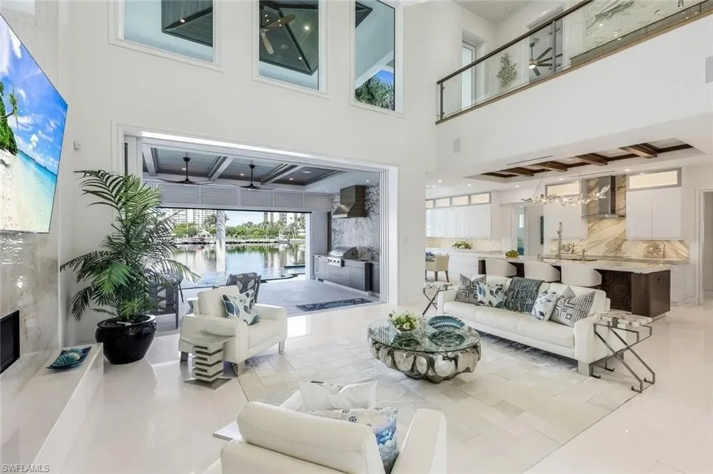 Infinity-edge saltwater pool and private dock at luxury home in Naples for sale, located on Venetian Bay with waterfront views.