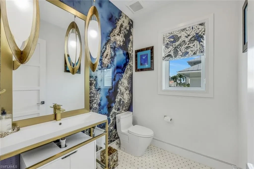 Infinity-edge saltwater pool and private dock at luxury home in Naples for sale, located on Venetian Bay with waterfront views.