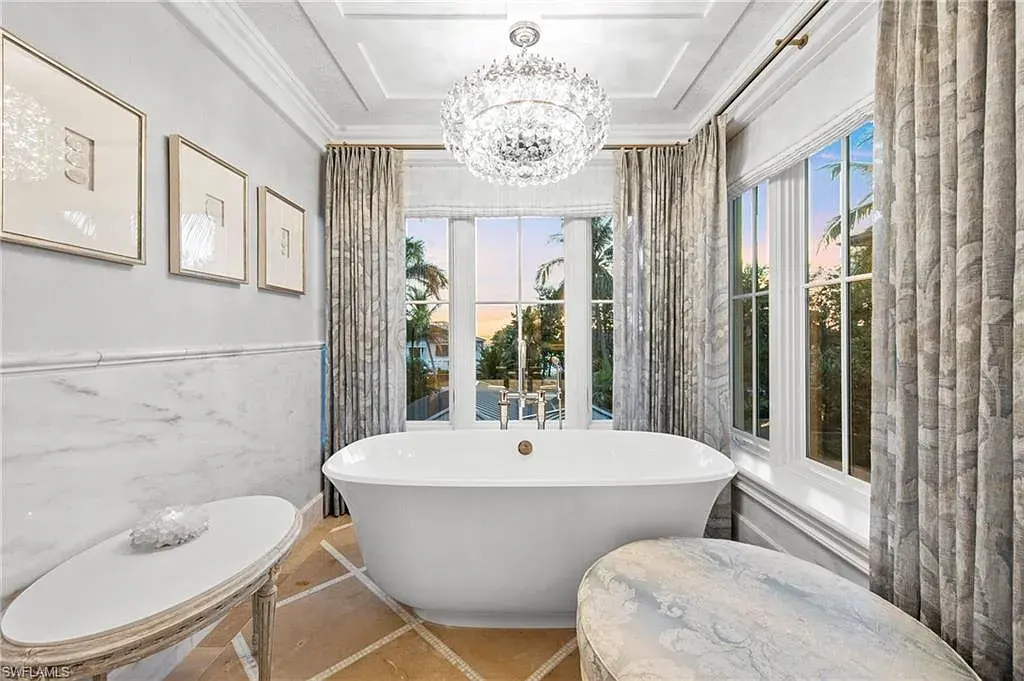 3675 Gordon Dr luxury home in Naples featuring French West Indies design, private beach access, koi pond, resort-style pool, and Gulf-access dock.