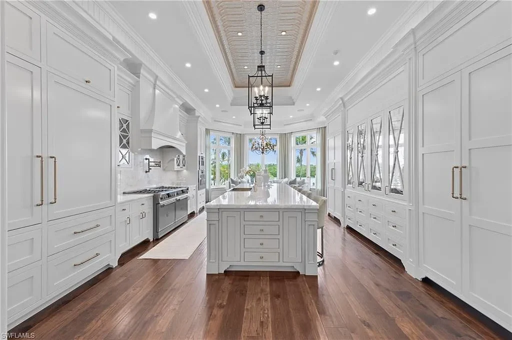 3675 Gordon Dr luxury home in Naples featuring French West Indies design, private beach access, koi pond, resort-style pool, and Gulf-access dock.