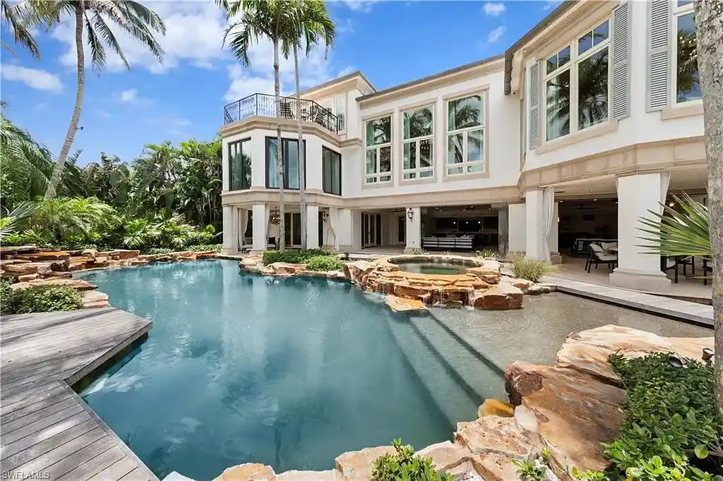 3675 Gordon Dr luxury home in Naples featuring French West Indies design, private beach access, koi pond, resort-style pool, and Gulf-access dock.