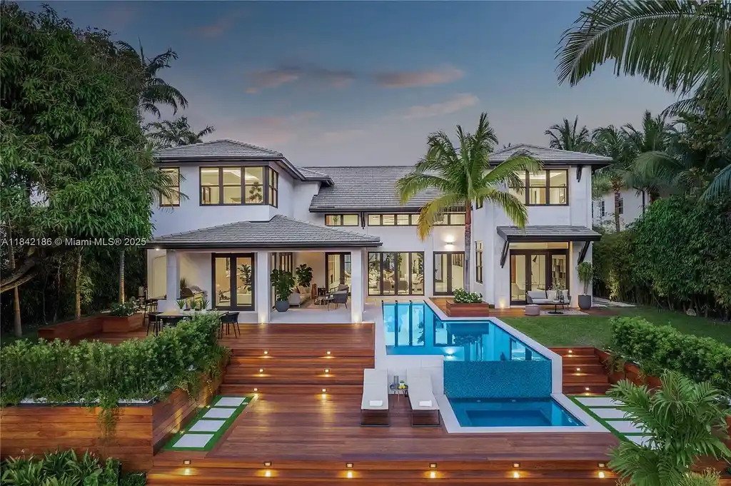 Luxurious waterfront home at 4241 Palm Ln in Miami featuring private dock, infinity-edge pool, modern tropical architecture, and lush Ipe wood deck