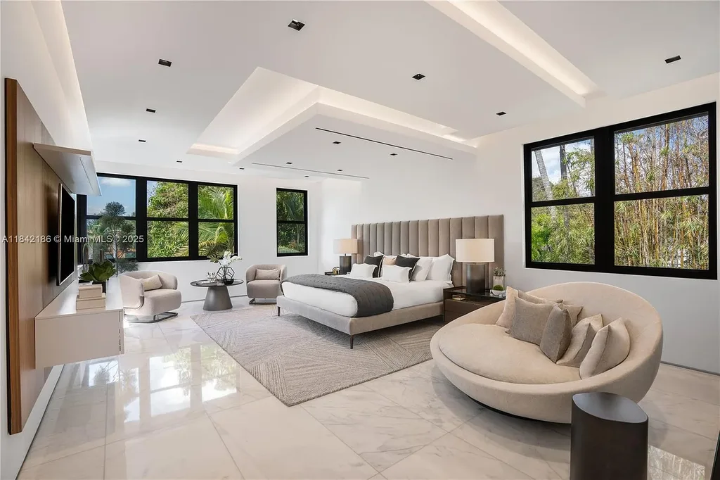 Luxurious waterfront home at 4241 Palm Ln in Miami featuring private dock, infinity-edge pool, modern tropical architecture, and lush Ipe wood deck
