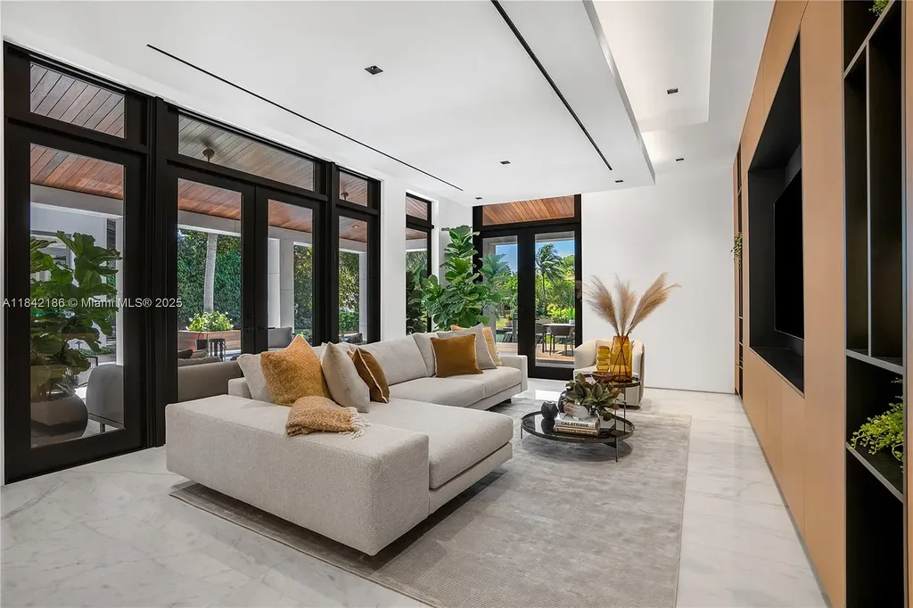 Luxurious waterfront home at 4241 Palm Ln in Miami featuring private dock, infinity-edge pool, modern tropical architecture, and lush Ipe wood deck