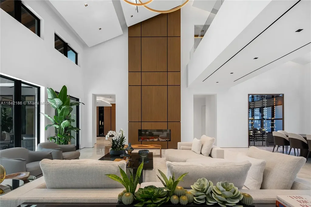 Luxurious waterfront home at 4241 Palm Ln in Miami featuring private dock, infinity-edge pool, modern tropical architecture, and lush Ipe wood deck
