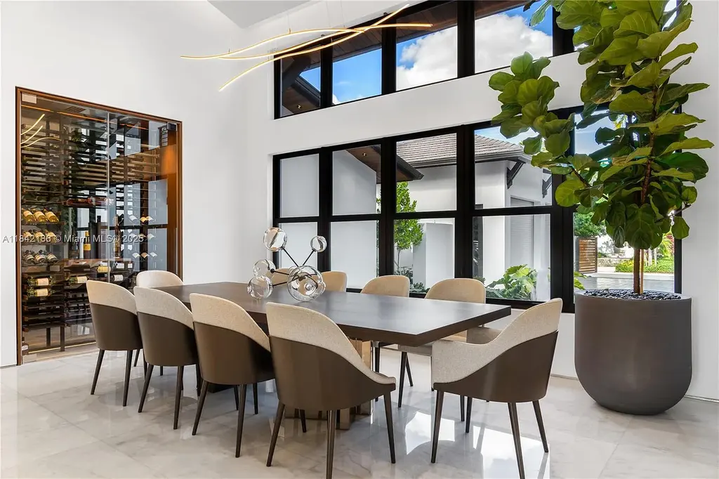 Luxurious waterfront home at 4241 Palm Ln in Miami featuring private dock, infinity-edge pool, modern tropical architecture, and lush Ipe wood deck