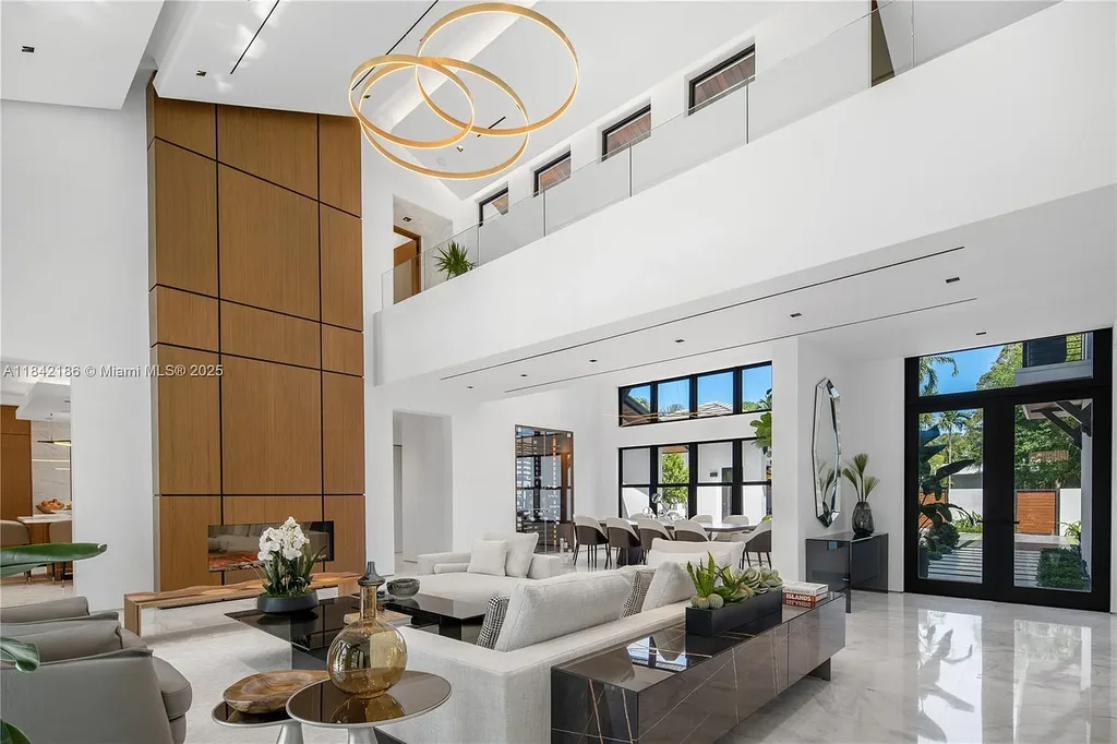 Luxurious waterfront home at 4241 Palm Ln in Miami featuring private dock, infinity-edge pool, modern tropical architecture, and lush Ipe wood deck