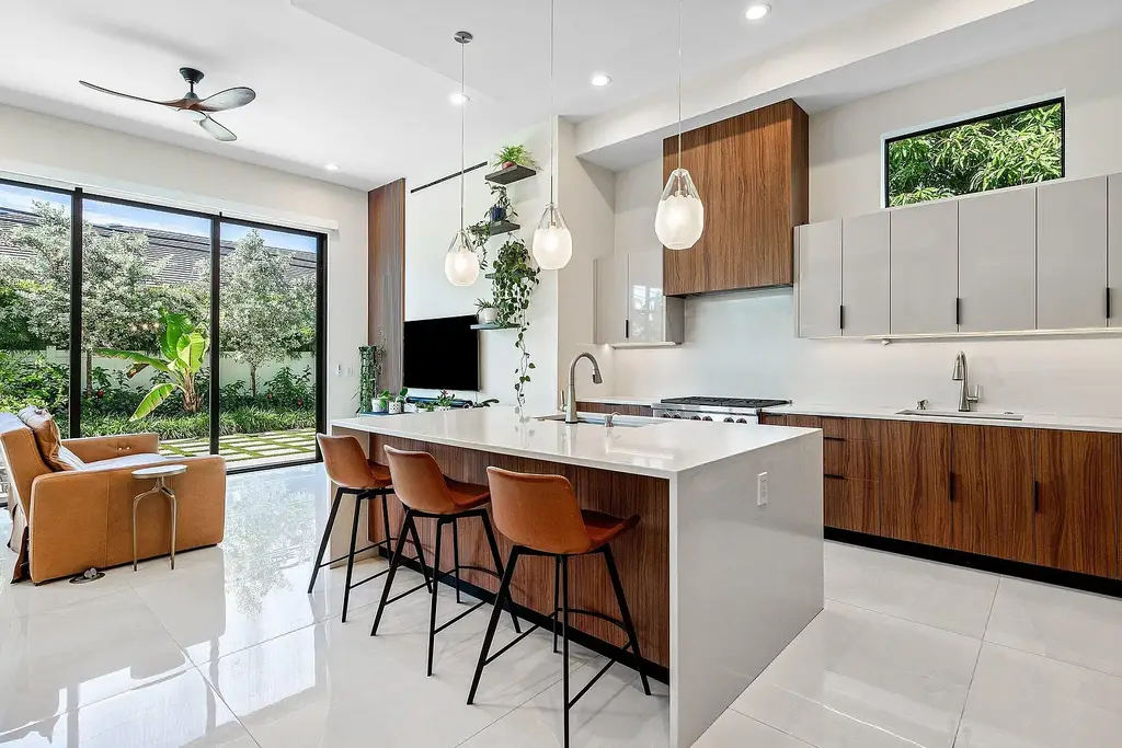 Modern living room inside 450 NE 10th Street featuring soaring ceilings, impact glass, and remote-control fireplace
