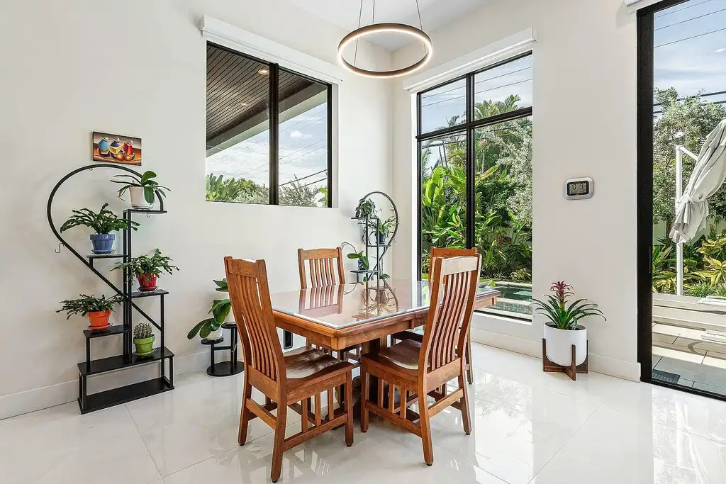Modern living room inside 450 NE 10th Street featuring soaring ceilings, impact glass, and remote-control fireplace