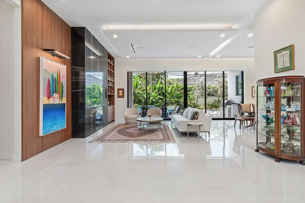 Modern living room inside 450 NE 10th Street featuring soaring ceilings, impact glass, and remote-control fireplace