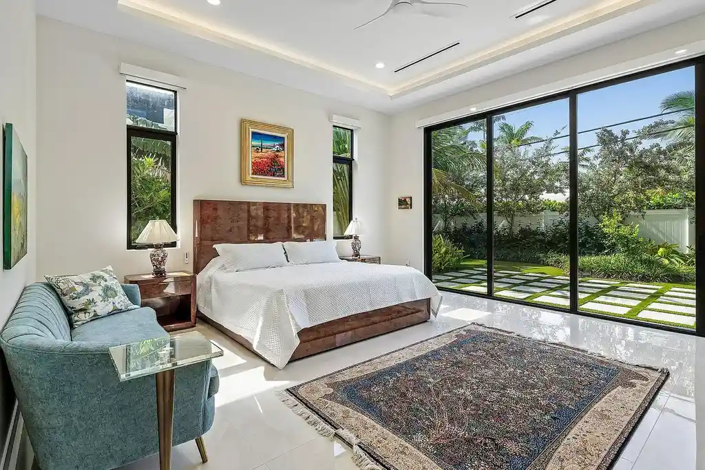 Modern living room inside 450 NE 10th Street featuring soaring ceilings, impact glass, and remote-control fireplace