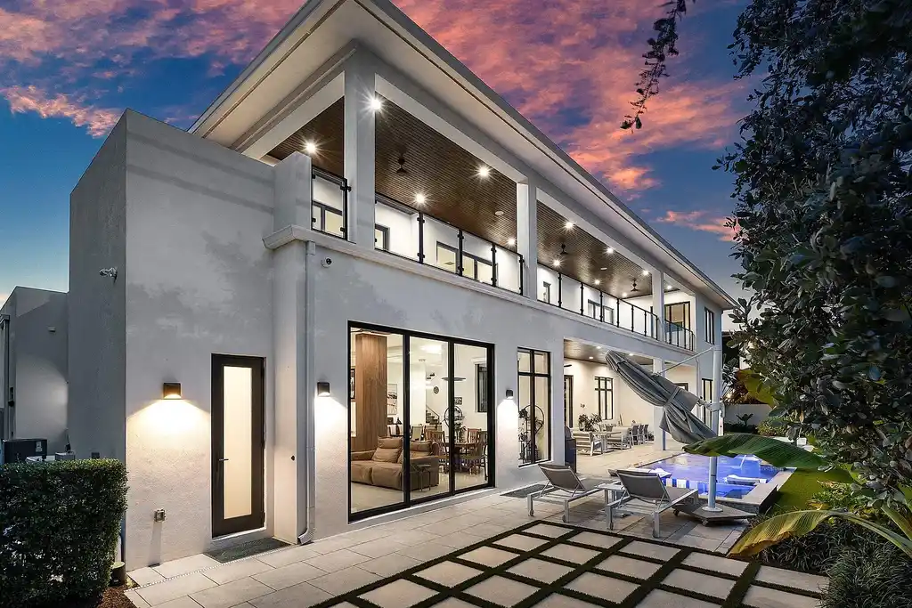 Modern living room inside 450 NE 10th Street featuring soaring ceilings, impact glass, and remote-control fireplace