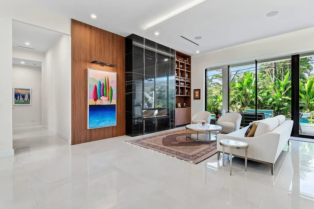 Modern living room inside 450 NE 10th Street featuring soaring ceilings, impact glass, and remote-control fireplace