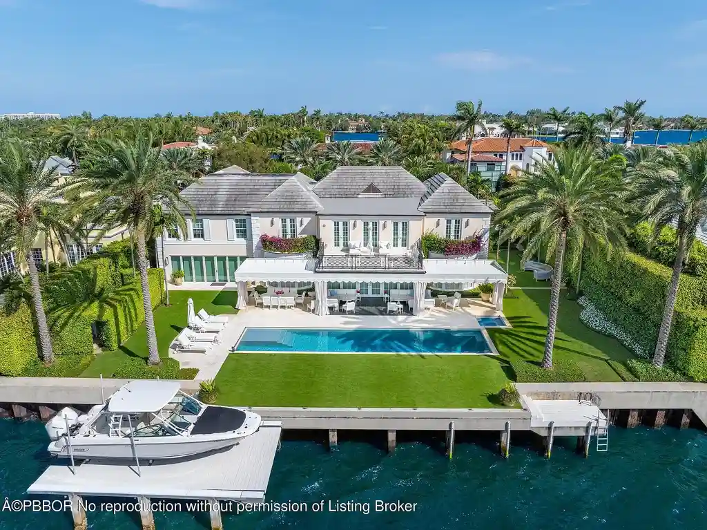 Aerial view of 631 Island Dr in Palm Beach, showcasing Georgian-style architecture, lush landscape, private dock, and direct Intracoastal frontage