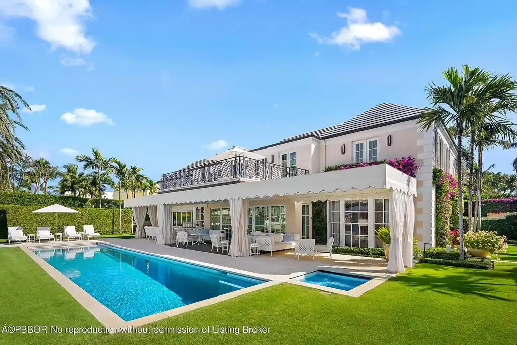 Aerial view of 631 Island Dr in Palm Beach, showcasing Georgian-style architecture, lush landscape, private dock, and direct Intracoastal frontage