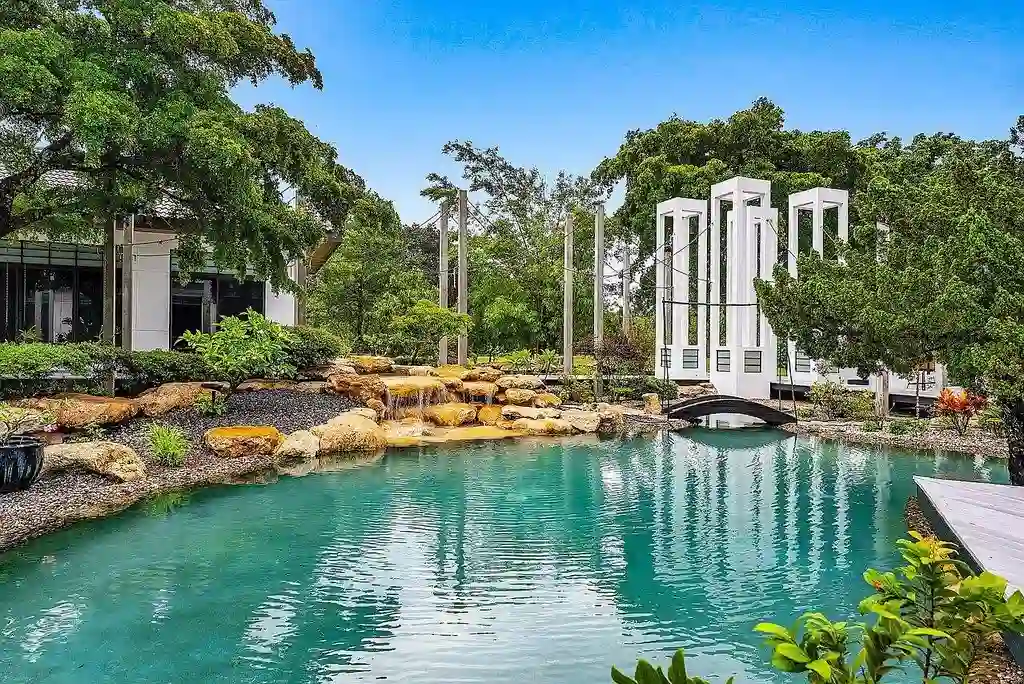 Front view of 8549 Surrey Lane featuring private gated entry and lush tropical landscaping in Boca Raton