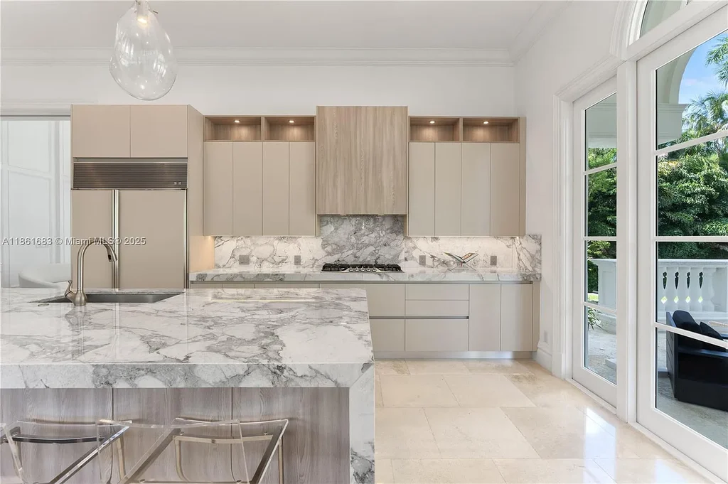 Luxury waterfront estate at 26 Tahiti Beach Island Rd in Coral Gables, FL featuring 6 bedrooms, 9,440 sq ft, private pool, and resort-style amenities.