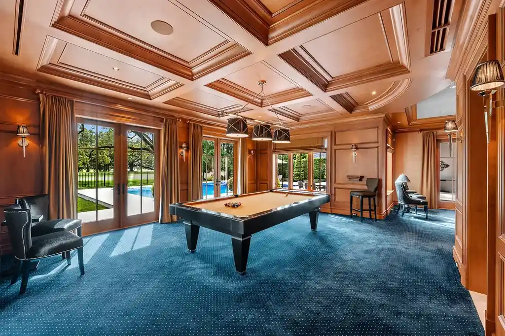 Outdoor living space with heated saltwater pool, cabana, and manicured gardens overlooking golf course